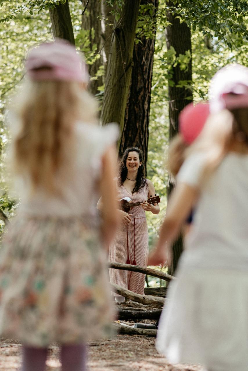 Kinder schauen aufmerksam bei der Waldmusikpädagogik zu