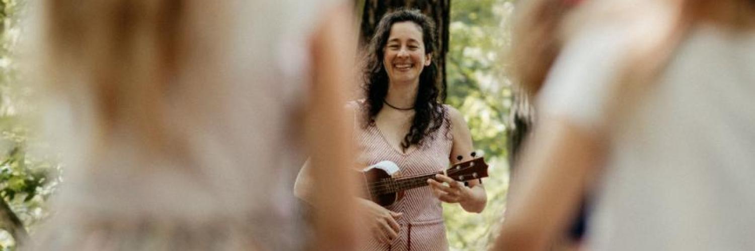 Kinder schauen aufmerksam bei der Waldmusikpädagogik zu