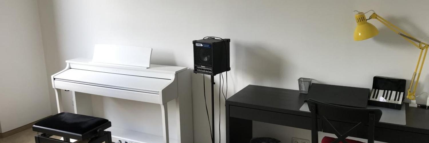 Heller Unterrichtsraum mit weißem Digitalpiano und Keyboard