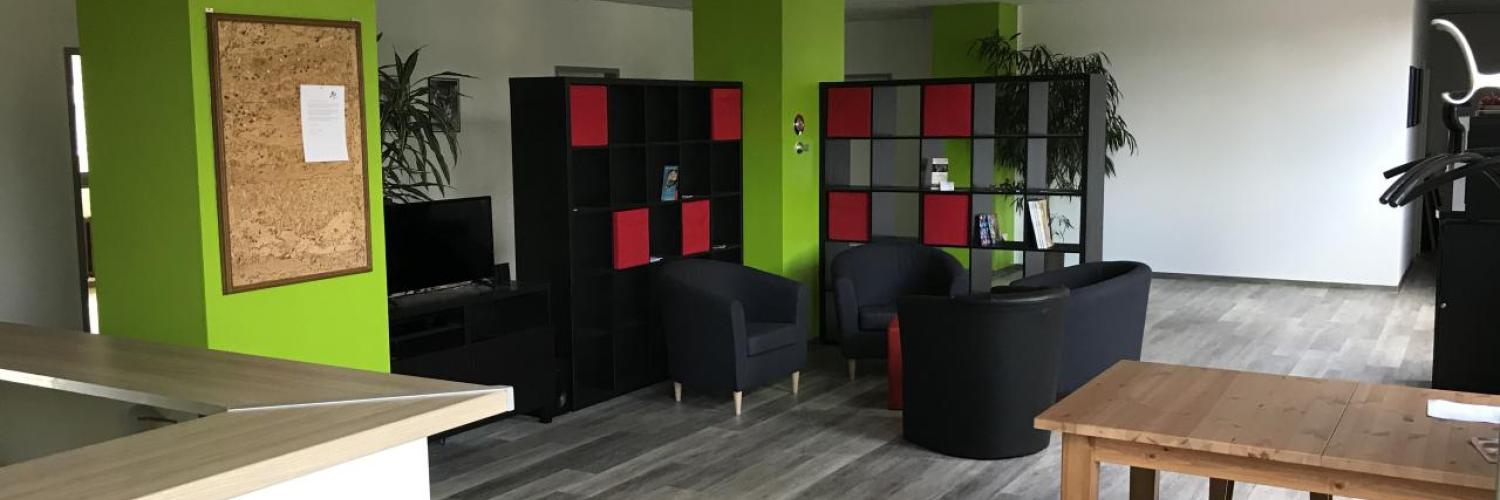 Aufenthaltsbereich der Further Musikschule Neuss mit Sesseln und Regalen